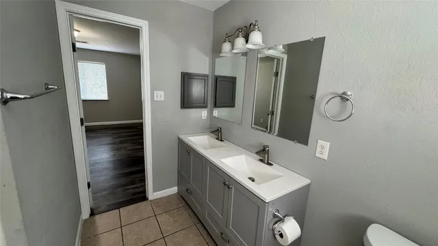 a bathroom with a sink a toilet and mirror
