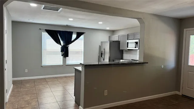 a view of two windows and a kitchen