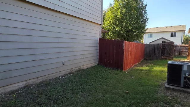 a view of backyard with small cabin and wooden fencing