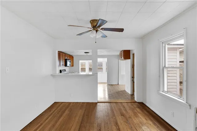 a view of a livingroom with wooden floor and a ceiling fan