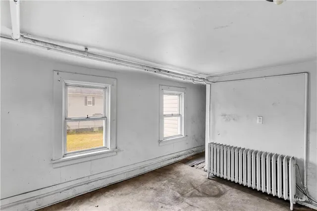 a view of an empty room with window and closet area