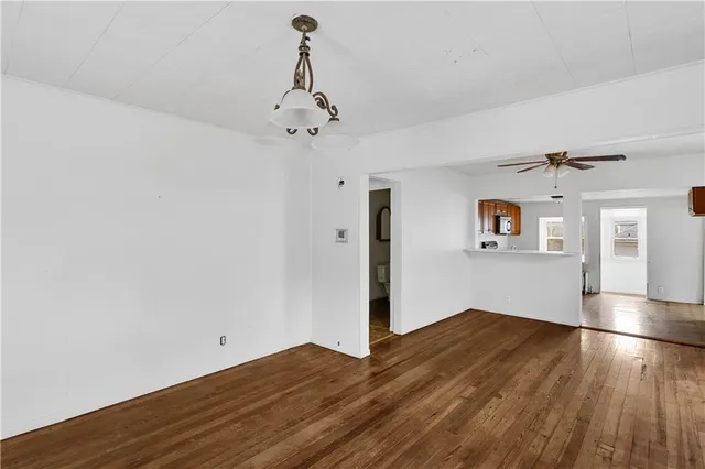 a view of a room with wooden floor and ceiling fan