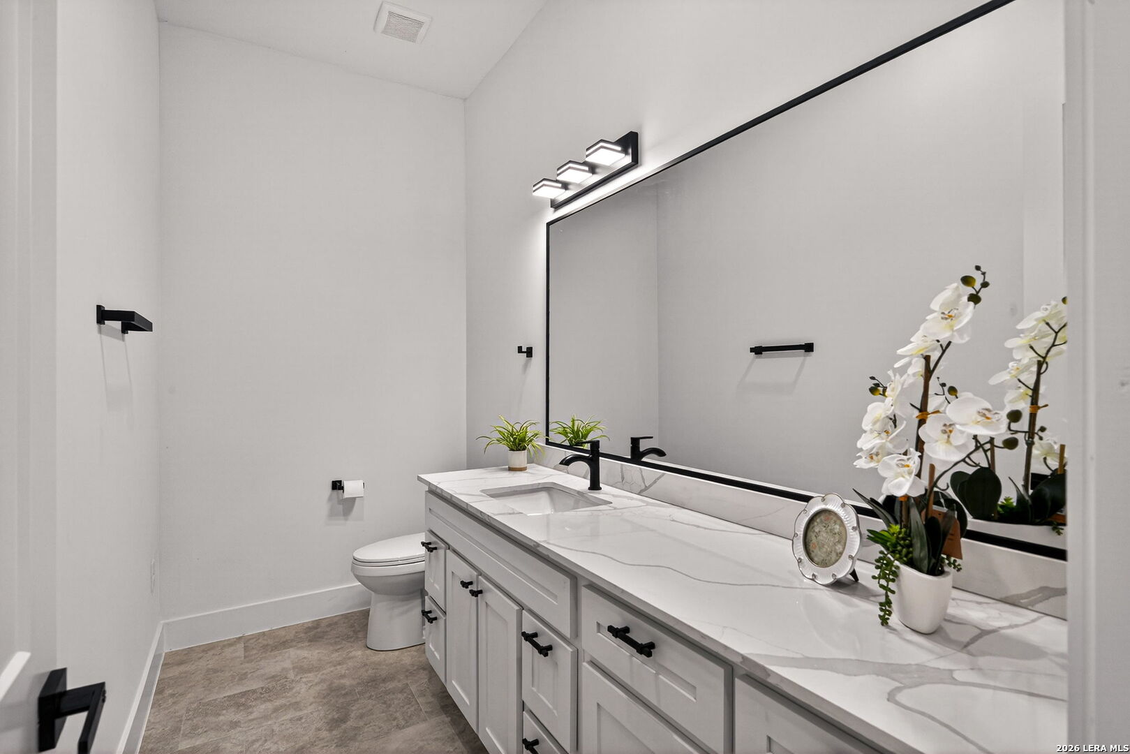 344 Buckskin Trail Bandera, TX 78003 - Photo 18 of 50 a bathroom with a granite countertop sink a toilet and a mirror