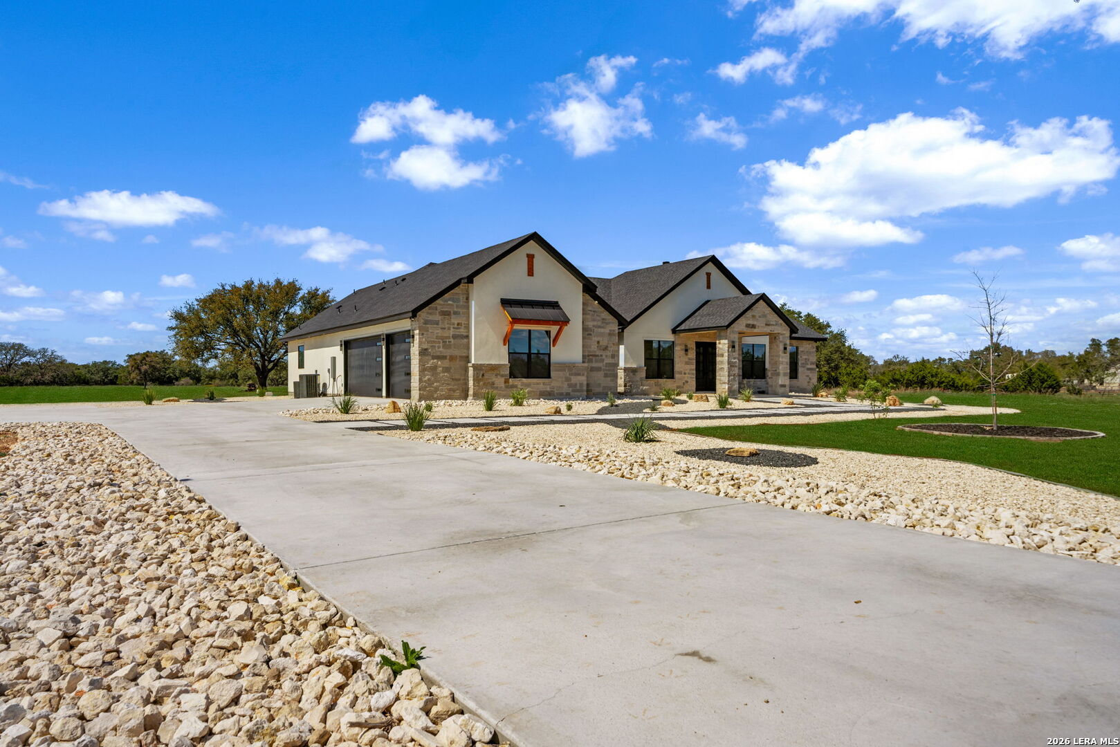 344 Buckskin Trail Bandera, TX 78003 - Photo 2 of 50 a front view of a house with a garden and yard