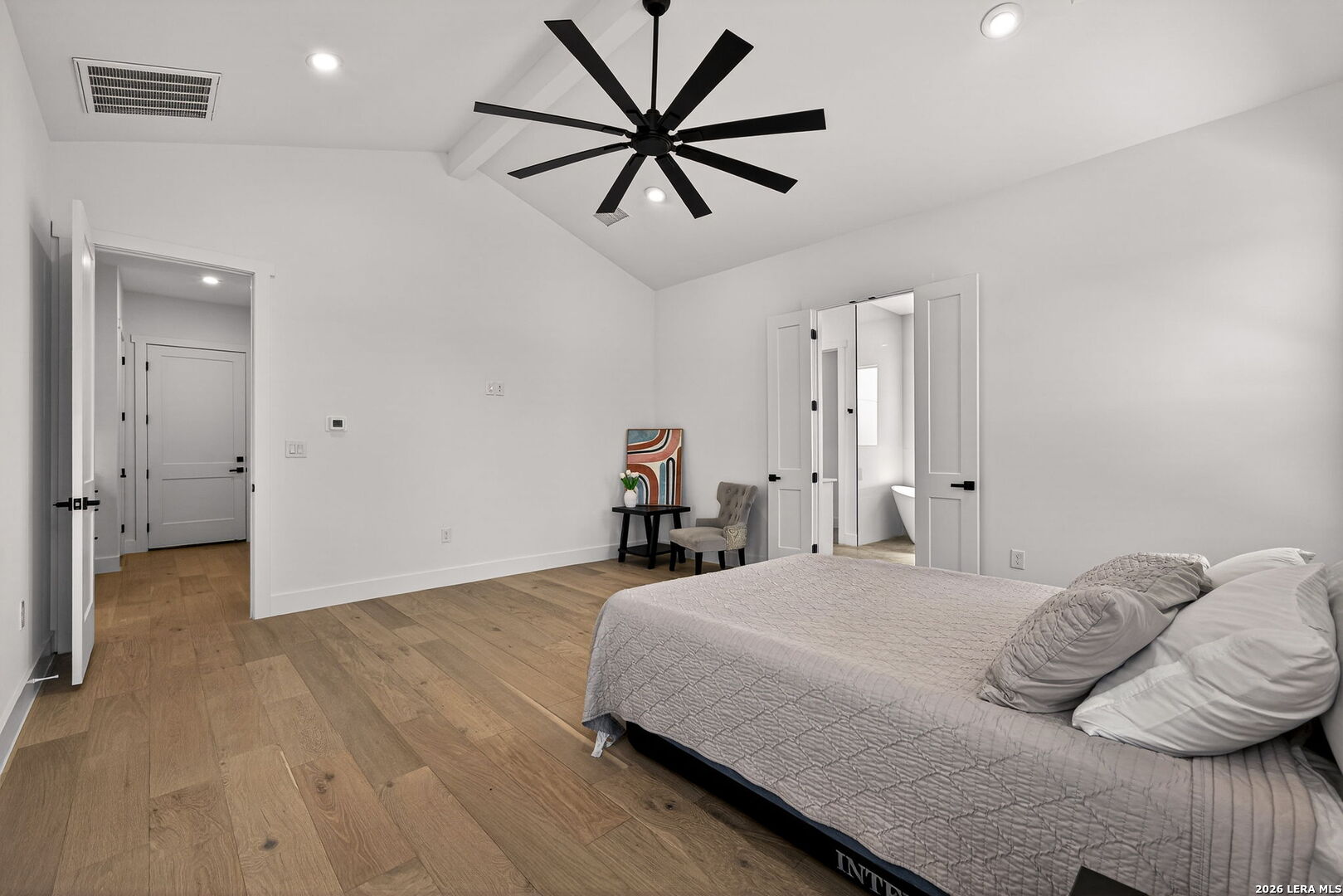 344 Buckskin Trail Bandera, TX 78003 - Photo 22 of 50 a bedroom with a bed and a chandelier