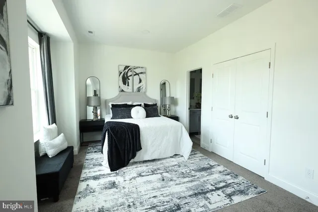 a spacious bedroom with a bed and a lamp