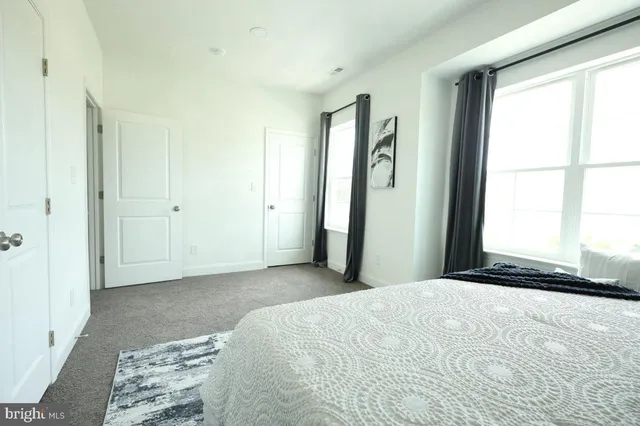 a bed sitting in a bedroom next to a window