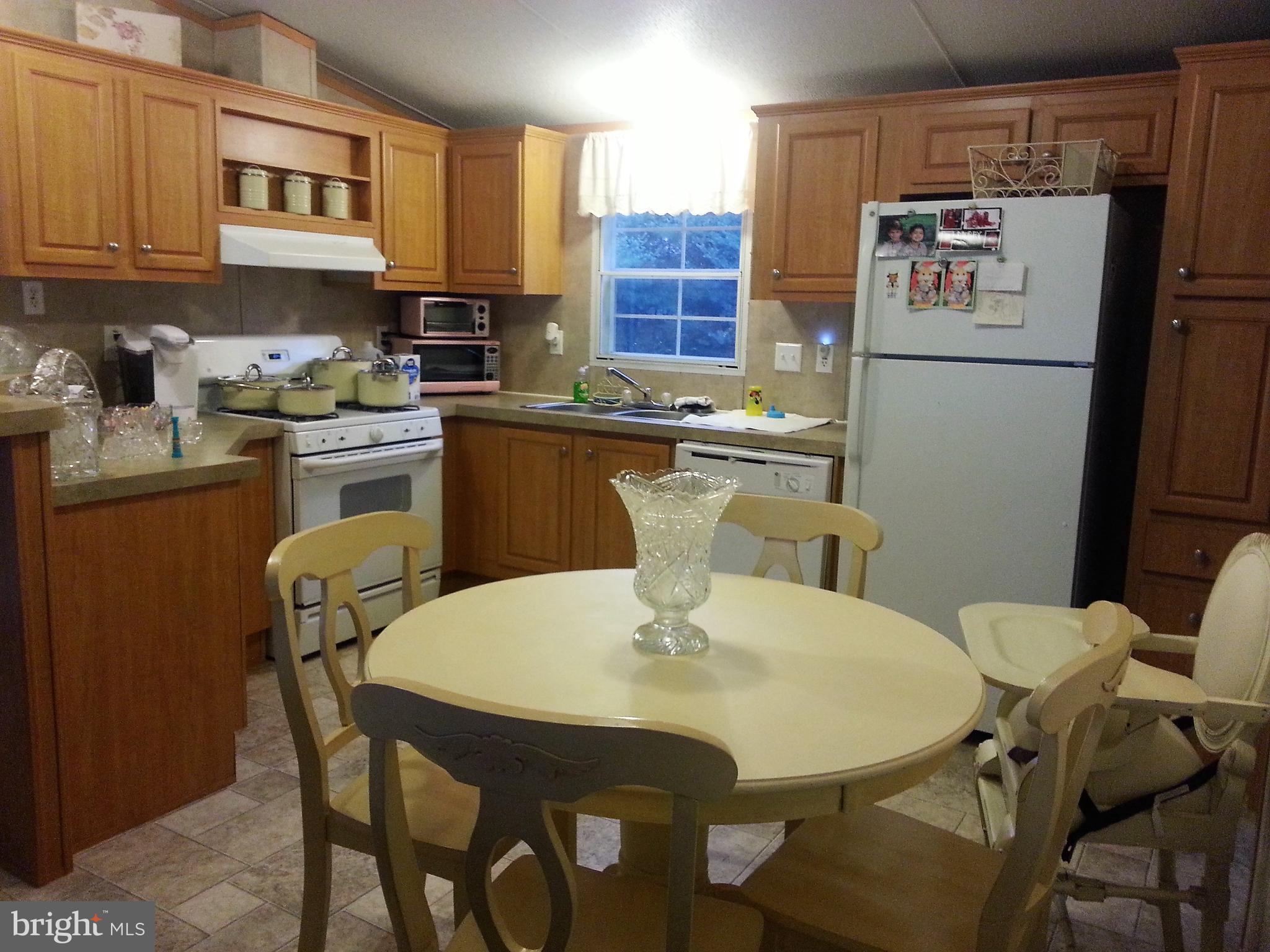3302 Forge Hill Road Street, MD 21154 - Photo 2 of 7 a kitchen with stainless steel appliances granite countertop a dining table and chairs
