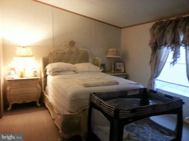 a bed sitting in a bedroom next to a window