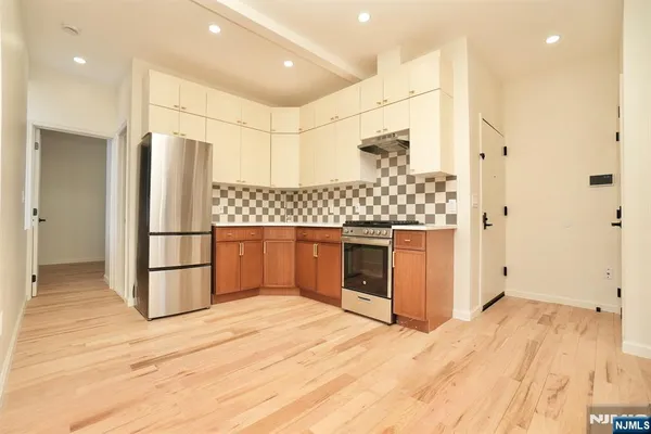 a kitchen with stainless steel appliances kitchen island granite countertop a refrigerator and a stove top oven