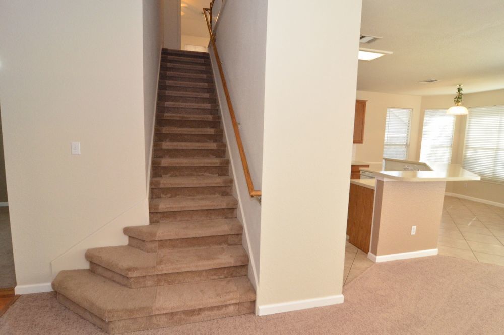 9405 Lightwood Loop Austin, TX 78748 - Photo 13 of 24 Carpeted staircase with wooden handrail