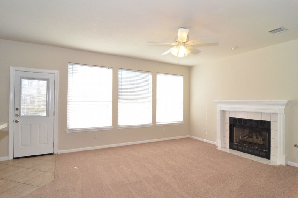 9405 Lightwood Loop Austin, TX 78748 - Photo 14 of 24 Living area featuring a fireplace with a white mantel and tile surround