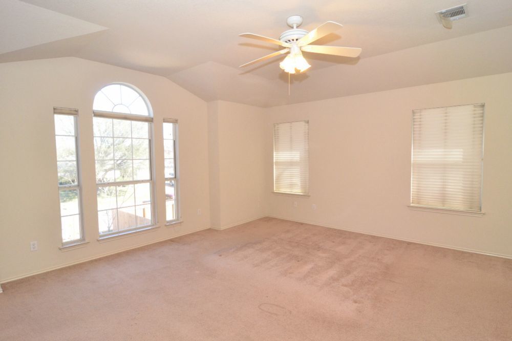 9405 Lightwood Loop Austin, TX 78748 - Photo 22 of 24 Spacious room with vaulted ceilings and neutral wall tones