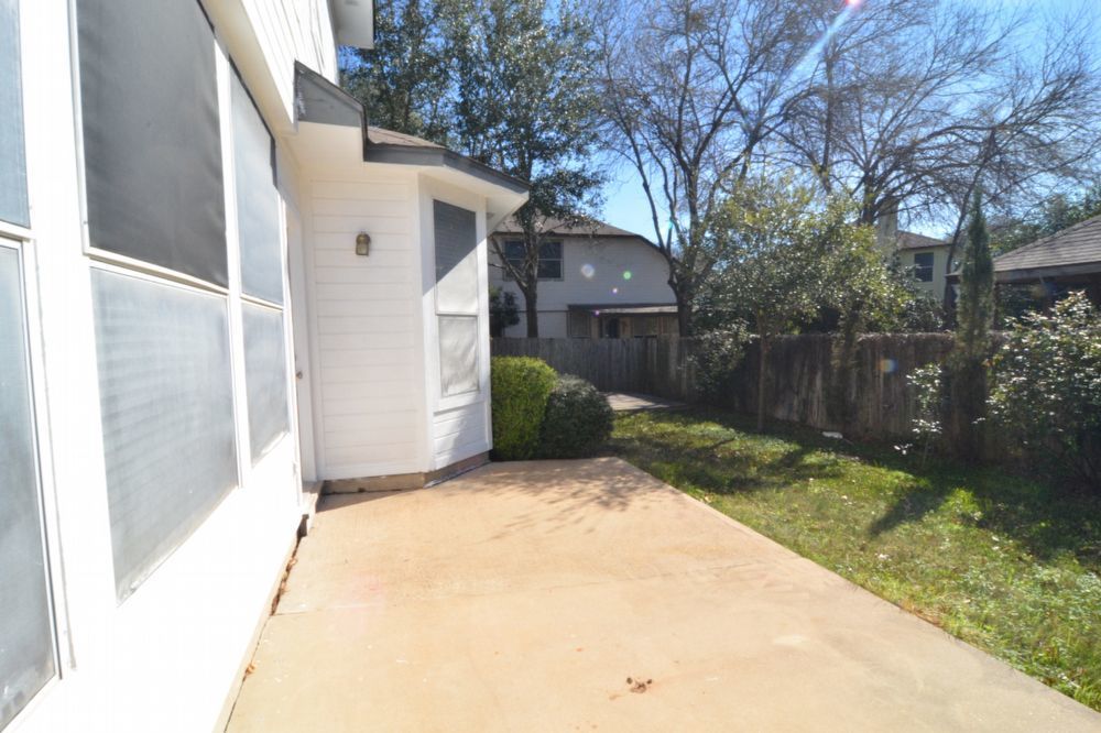 9405 Lightwood Loop Austin, TX 78748 - Photo 7 of 24 Concrete patio area alongside the residence, featuring white siding and a bay window