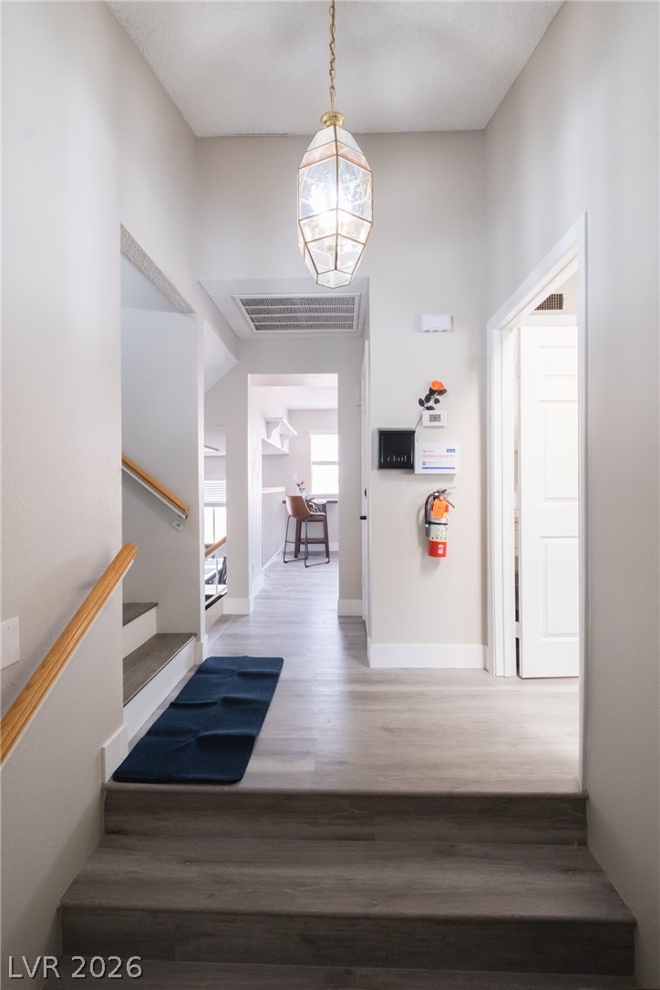 6356 West Viking Road Las Vegas, NV 89103 - Photo 4 of 51 Smooth wood-look flooring guides visitors from the entryway stairs into an open-concept layout.
