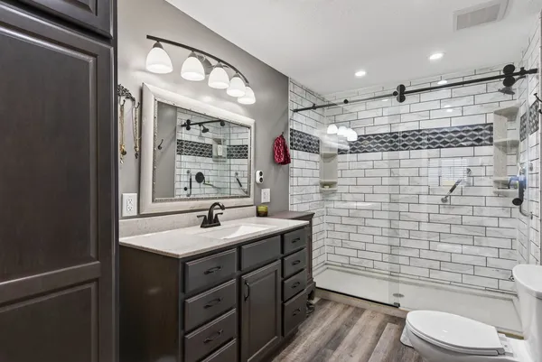 a bathroom with a sink a toilet and shower