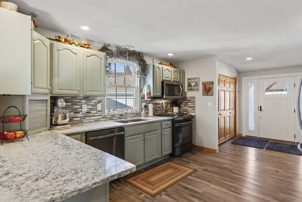 a kitchen with stainless steel appliances granite countertop a sink stove and refrigerator