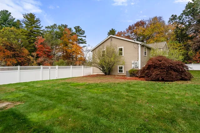 a view of a yard in front of a house with large trees