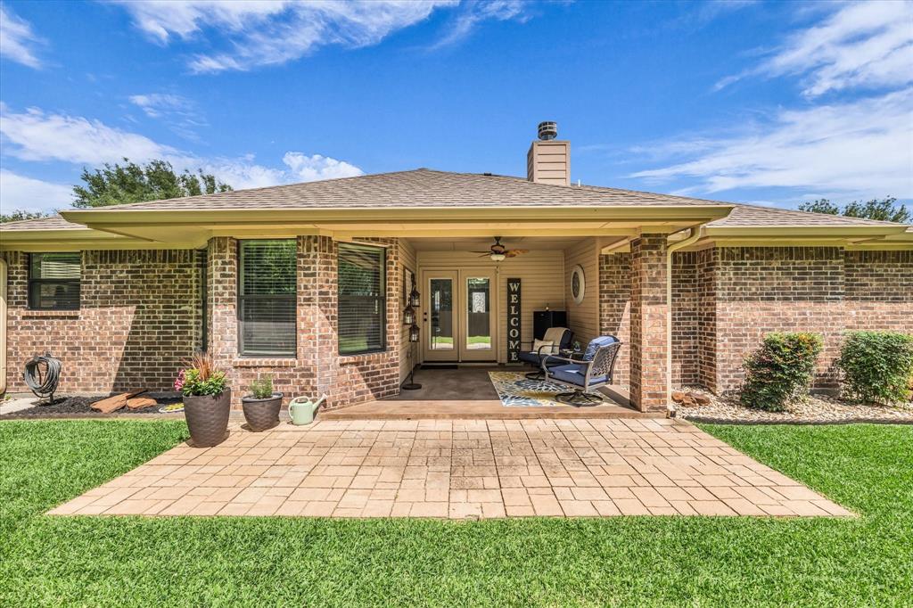814 Springdale Circle Lorena, TX 76655 - Photo 26 of 37 Brick exterior featuring a covered patio with an outdoor ceiling fan, double glass-paneled doors, and an extended paver patio