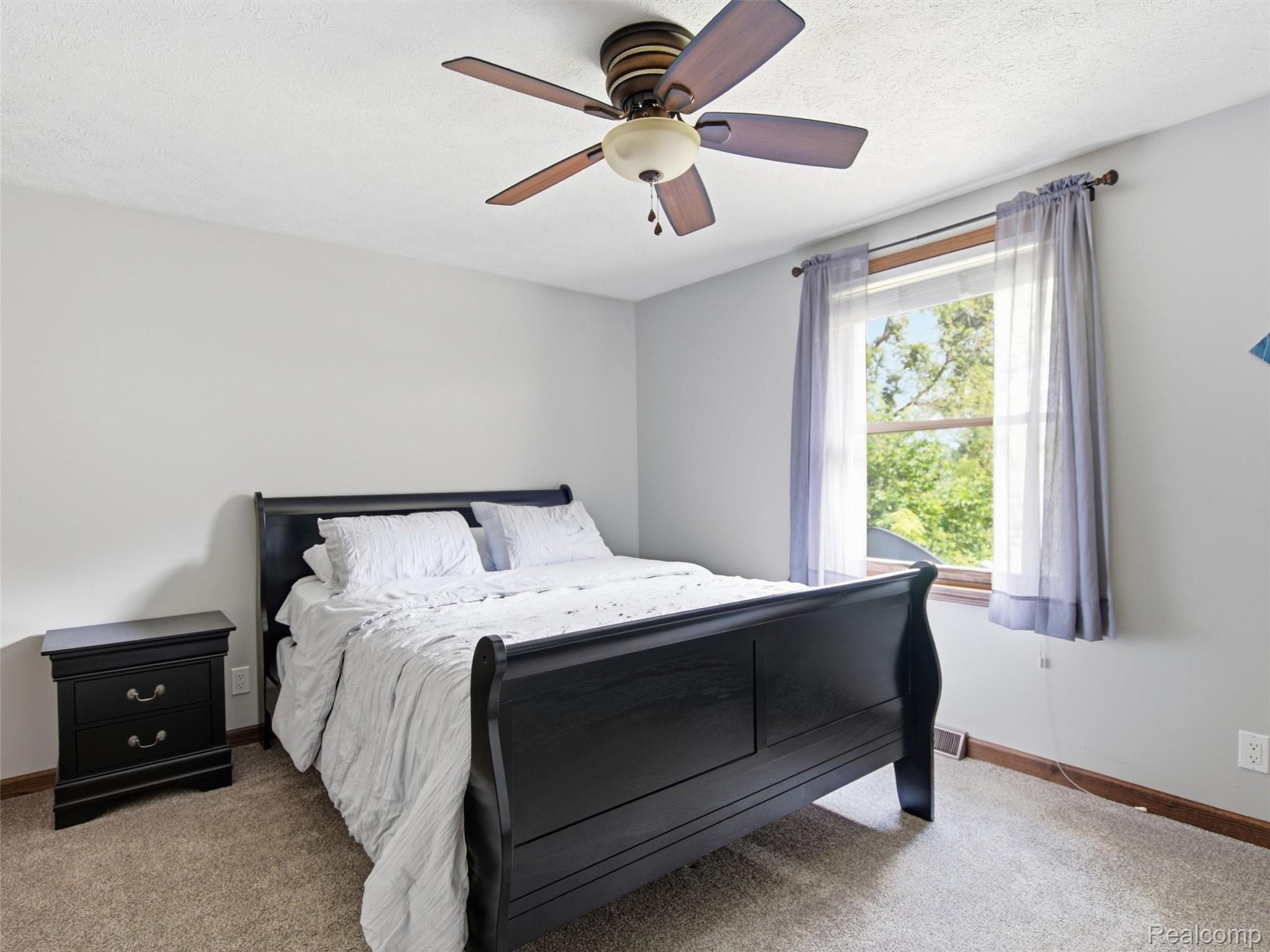 5003 Mason Road Howell, MI 48843 - Photo 22 of 59 Carpeted room featuring a ceiling fan with integrated lighting, a single window with a wood frame, and light gray walls