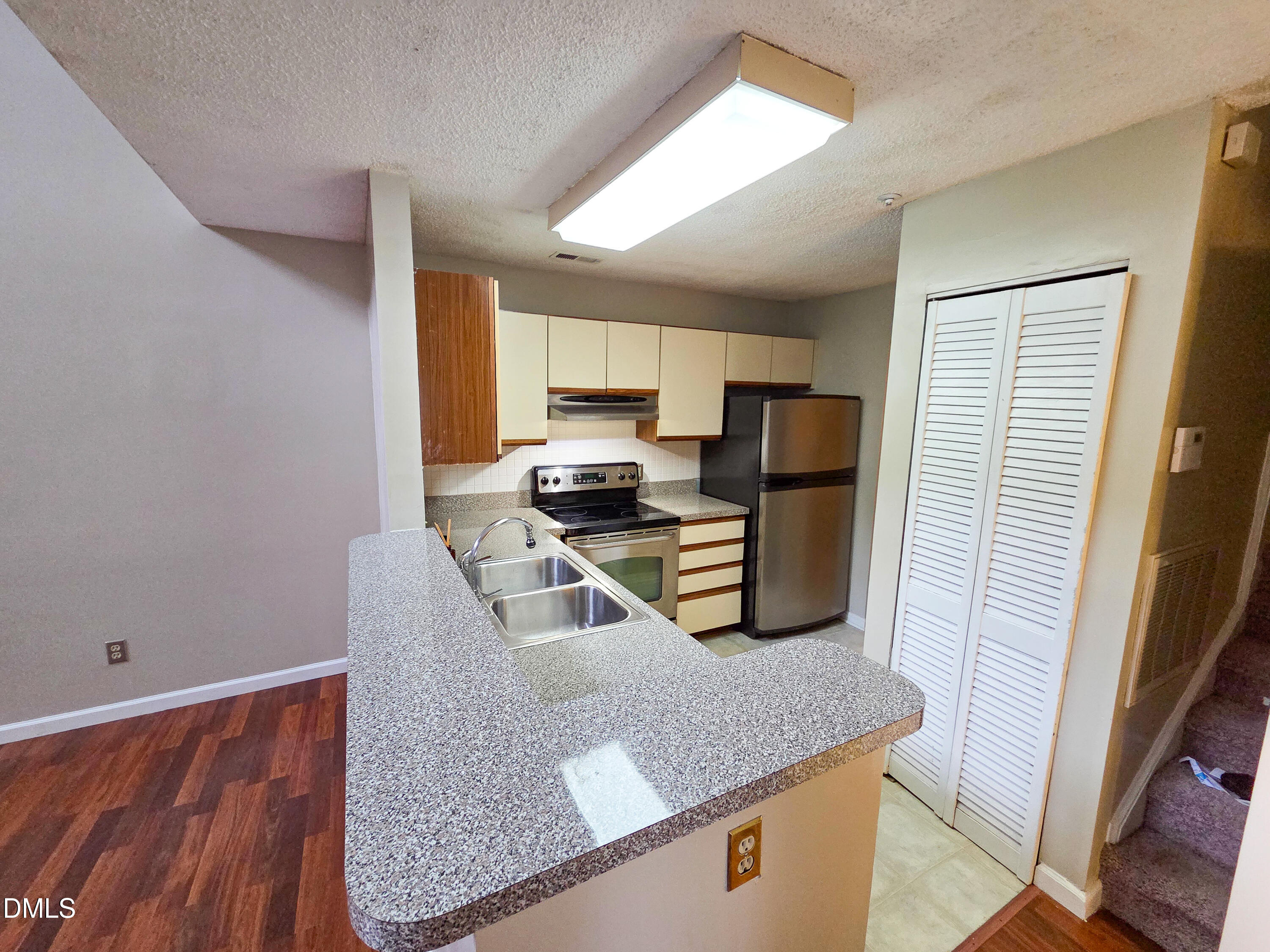 3810 Grey Harbor Drive, Unit 307 Raleigh, NC 27616 - Photo 10 of 25 a kitchen with granite countertop a refrigerator a stove a sink dishwasher and microwave with wooden floor