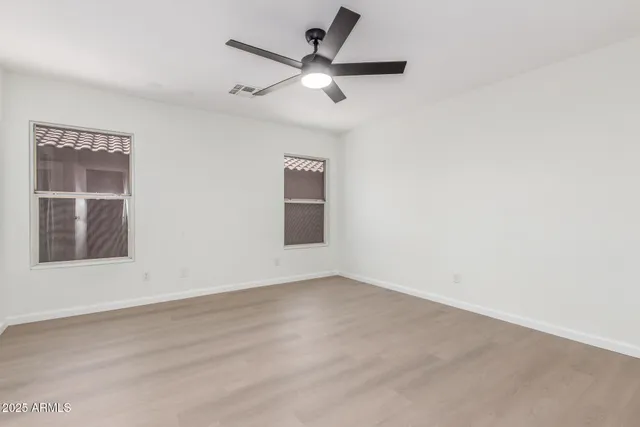 an empty room with a window and a fan