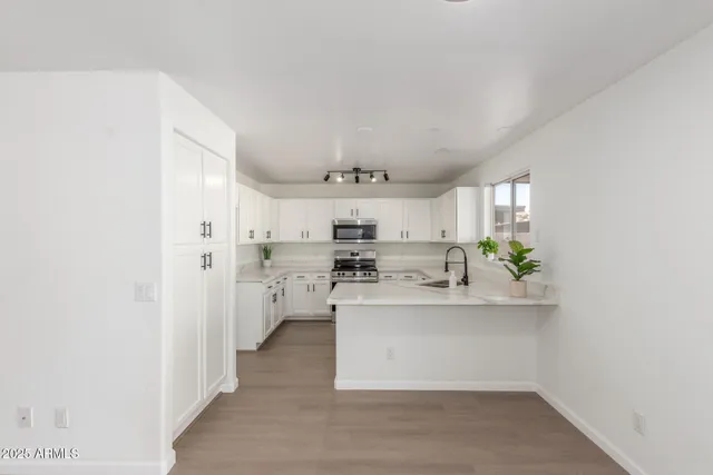 a kitchen with white cabinets and stainless steel appliances