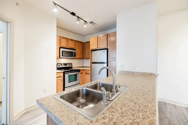 a kitchen with granite countertop a sink and a stove top oven