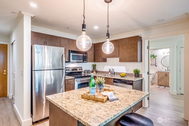 626 4th Avenue West, Unit 104 Seattle, WA 98119 - Photo 12 of 37 a kitchen with stainless steel appliances granite countertop a refrigerator a oven a sink a stove and island