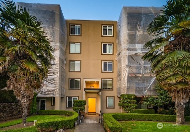 626 4th Avenue West, Unit 104 Seattle, WA 98119 - Photo 32 of 37 a front view of a residential apartment building with a yard and potted plants