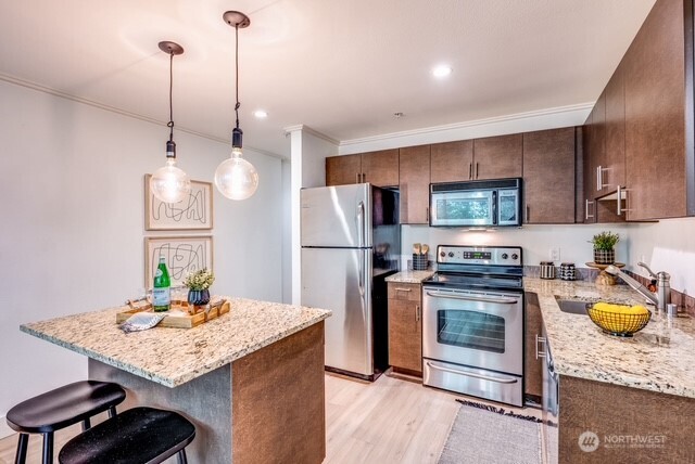 626 4th Avenue West, Unit 104 Seattle, WA 98119 - Photo 9 of 37 a kitchen with stainless steel appliances granite countertop a sink dishwasher a stove a refrigerator a microwave oven with a dining table and chairs