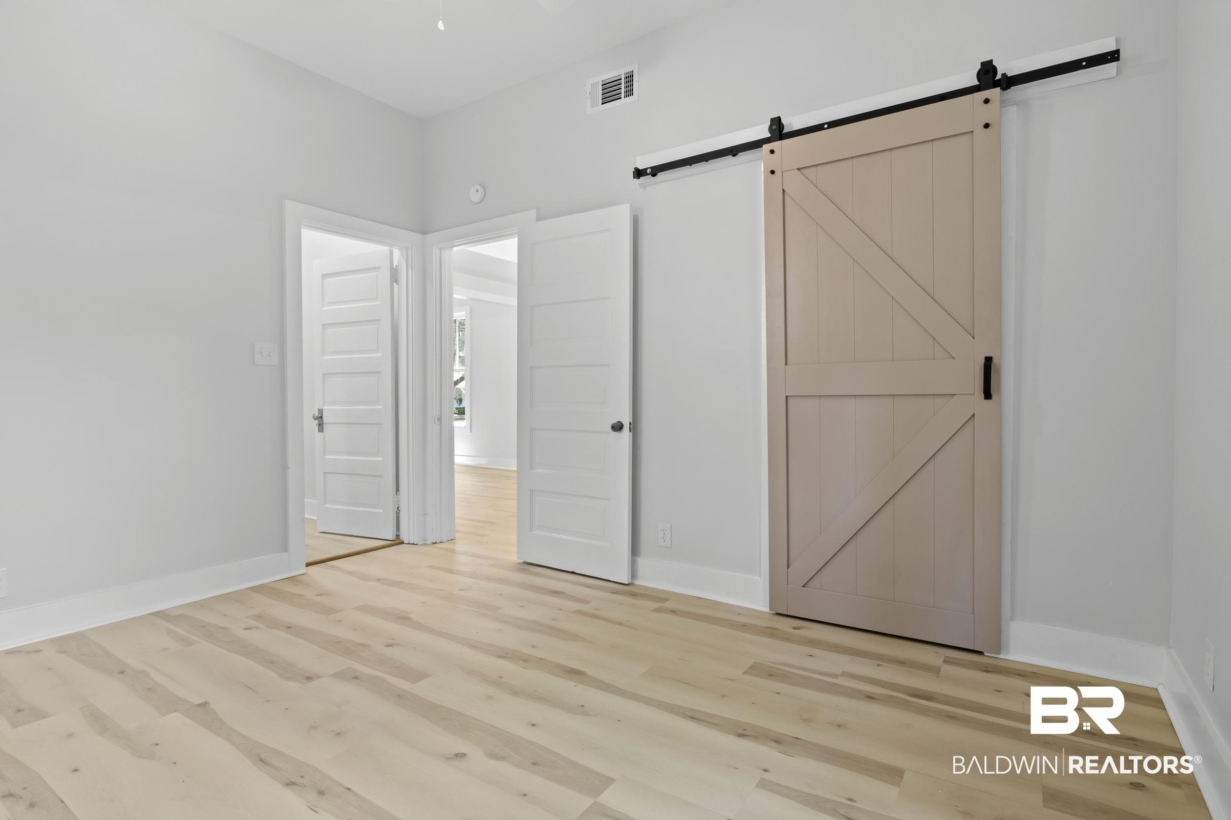 315 Park Avenue Mobile, AL 36607 - Photo 12 of 27 Unfurnished bedroom with light hardwood / wood-style flooring and a barn door