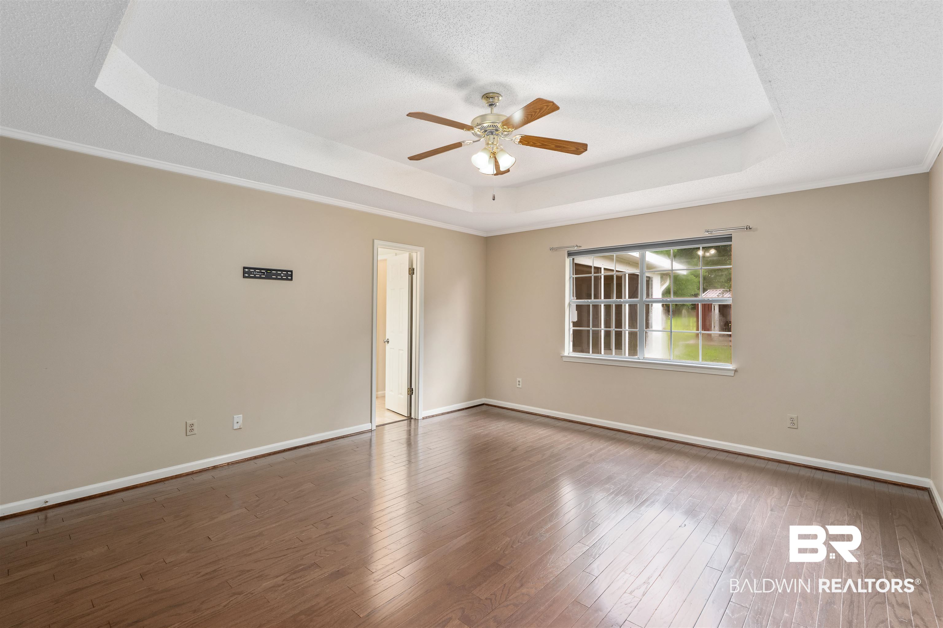 25779 Austin Road Daphne, AL 36526 - Photo 22 of 30 Primary bedroom with a raised ceiling, ceiling fan, hardwood / wood-style floors, baseboards, and a textured ceiling