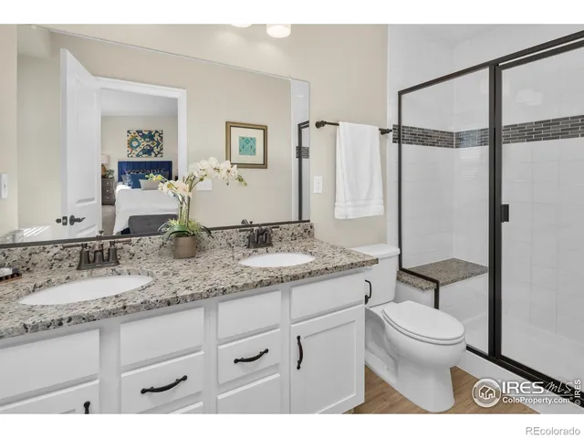 a bathroom with a granite countertop sink mirror vanity and toilet