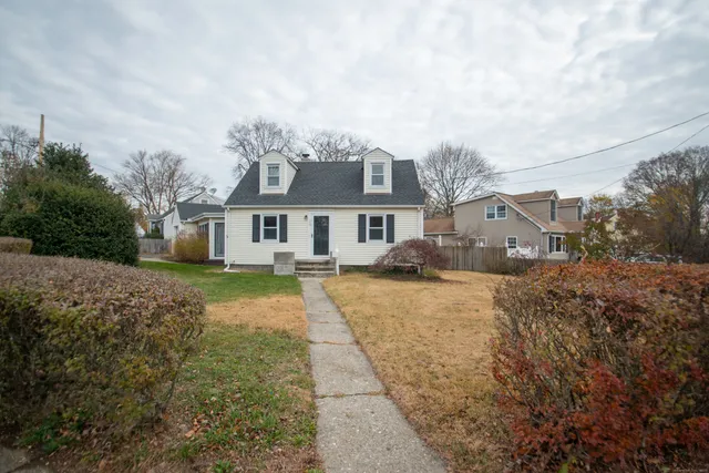 a front view of a house with a yard and trees
