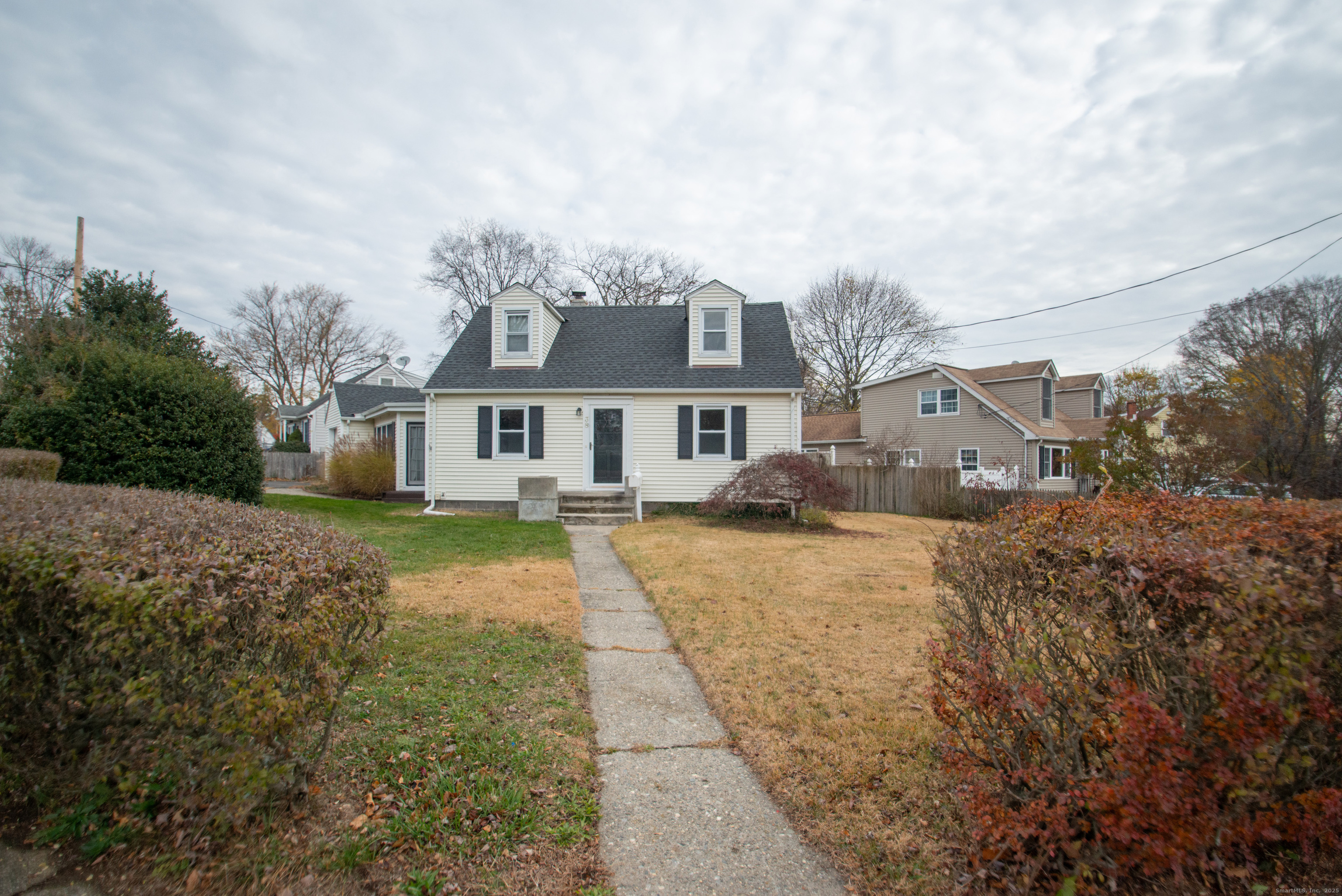 a front view of a house with a yard and trees