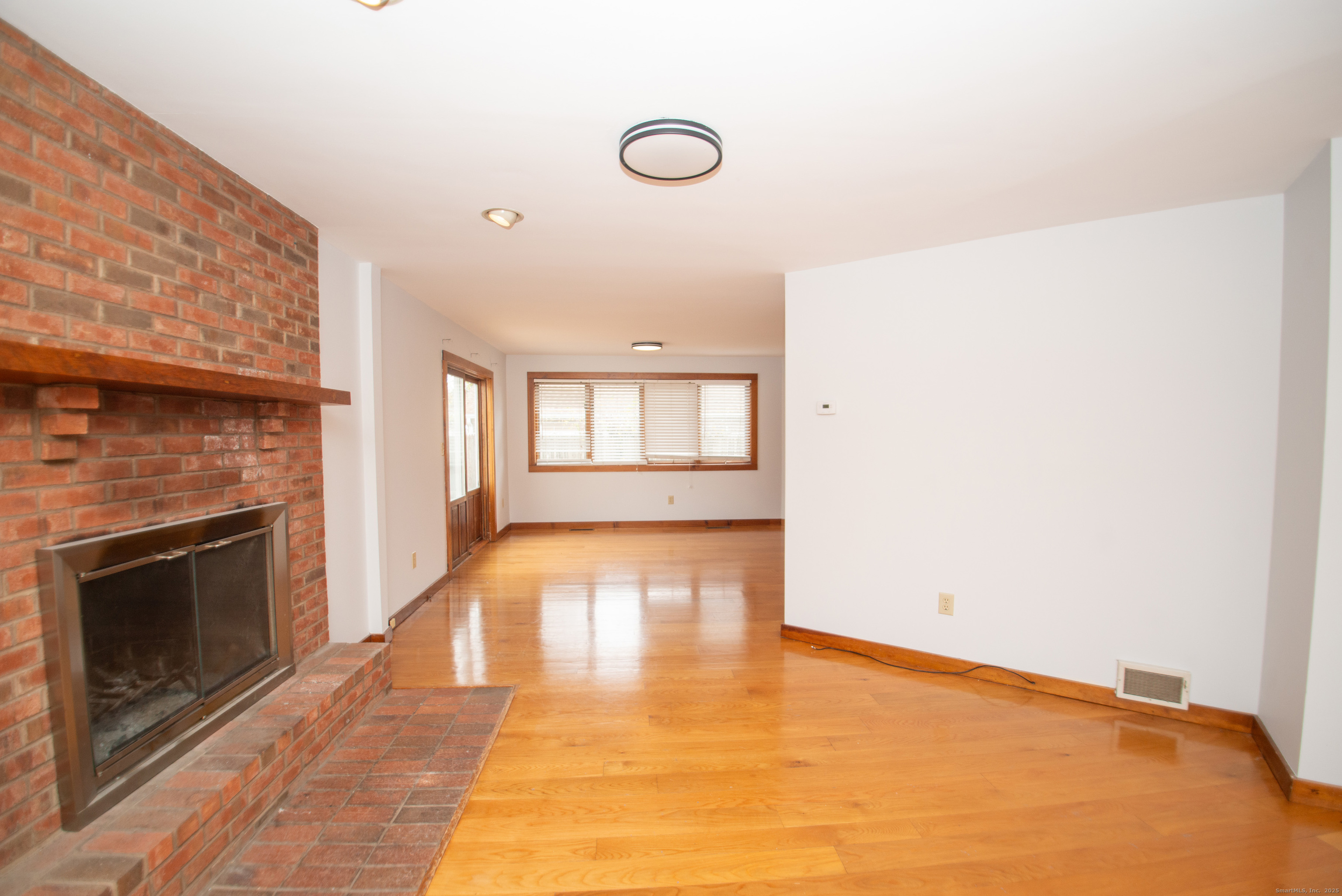 38 Wayland Road Milford, CT 06460 - Photo 14 of 39 a view of an empty room with a fireplace and wooden floor