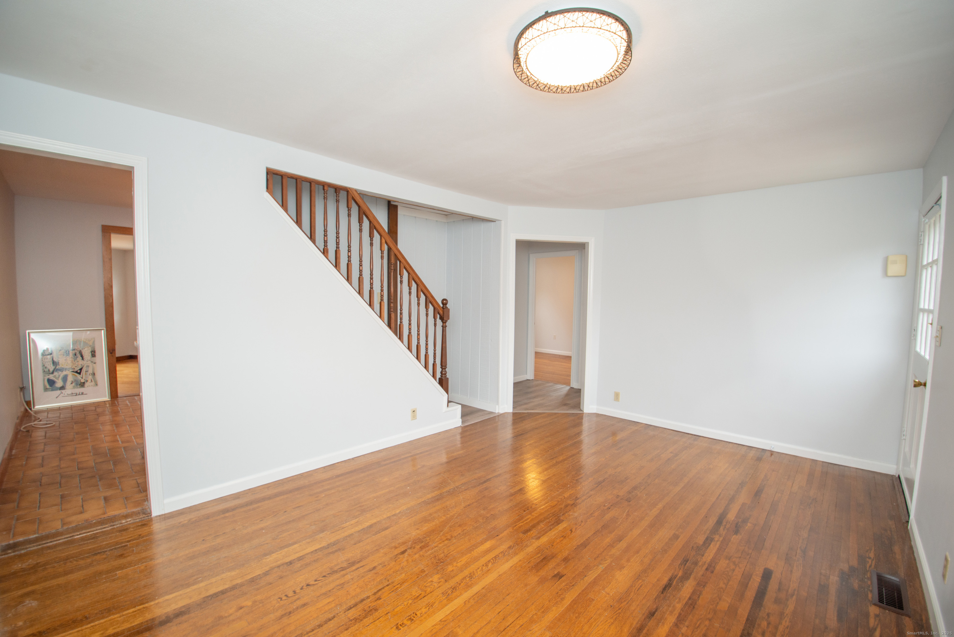 38 Wayland Road Milford, CT 06460 - Photo 22 of 39 a view of an empty room with wooden floor and a potted plant