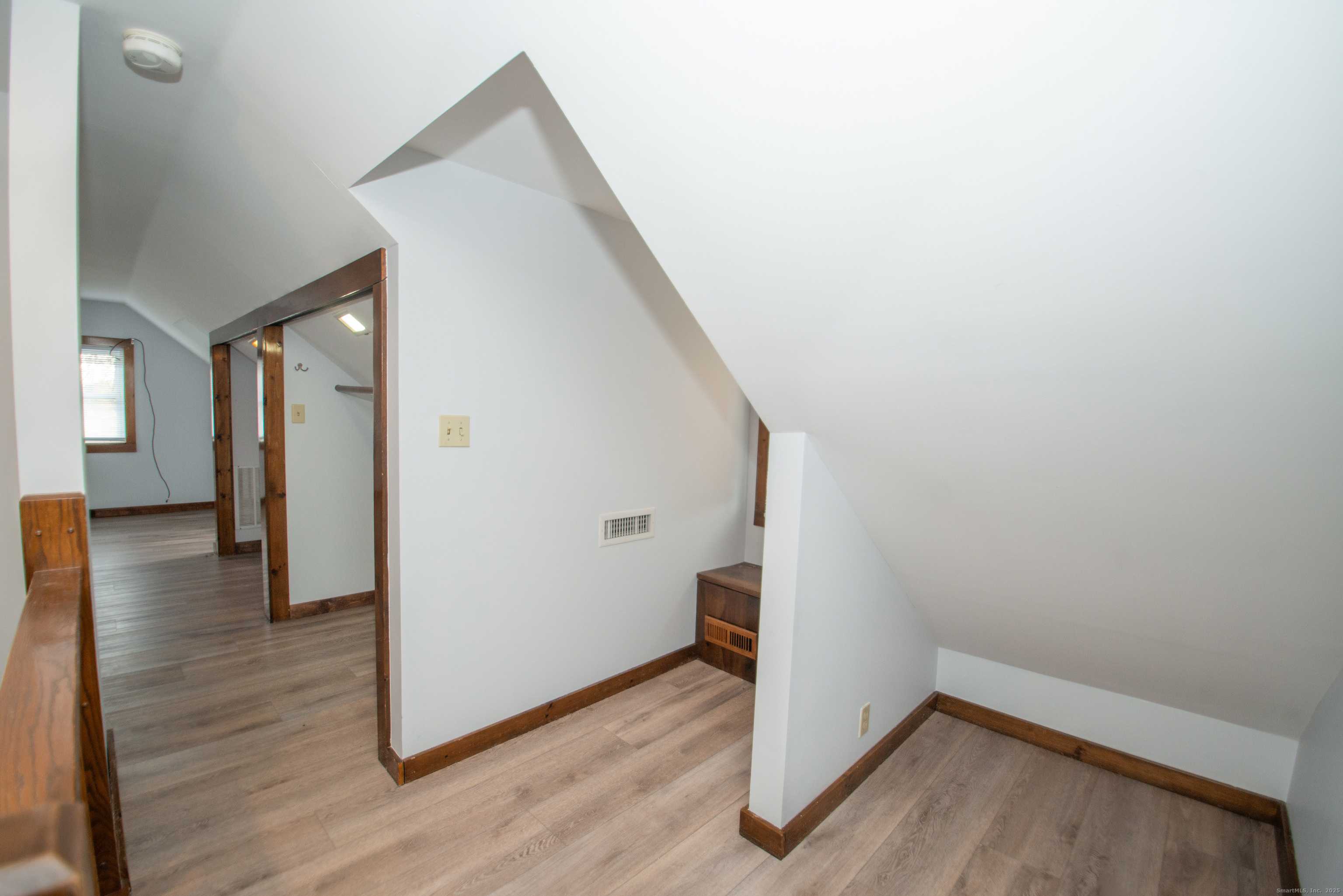 38 Wayland Road Milford, CT 06460 - Photo 33 of 39 a view of a hallway to an empty room with wooden floor and a window