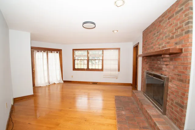 a view of an empty room with a fireplace and a window