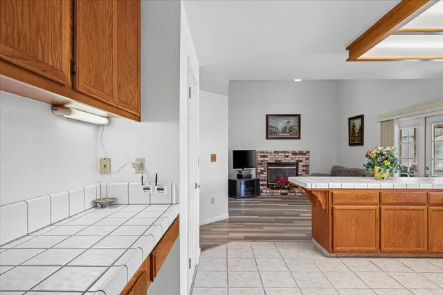 a kitchen with stainless steel appliances granite countertop a table chairs in it and wooden floors