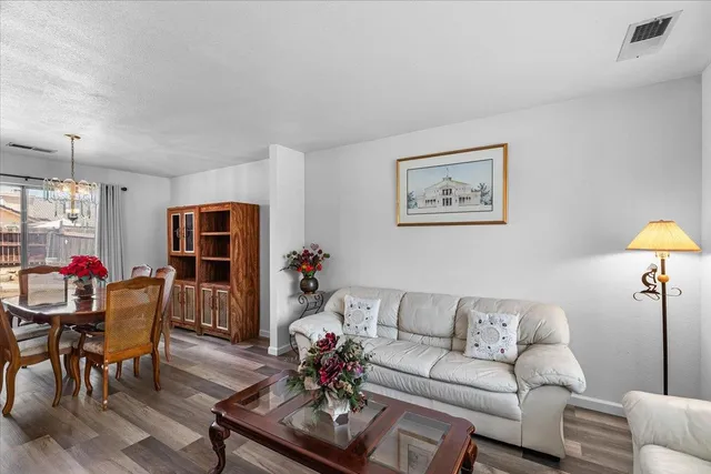 a dining room with furniture a chandelier and wooden floor