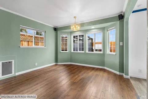 an empty room with wooden floor and ceiling fan