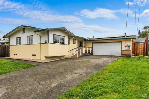 a dining room with wooden floor a chandelier a wooden table and chairs