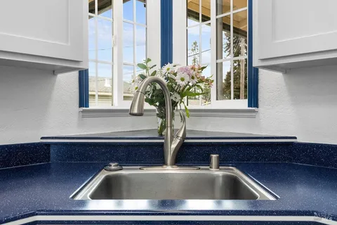 a kitchen with granite countertop a stove a sink and a microwave