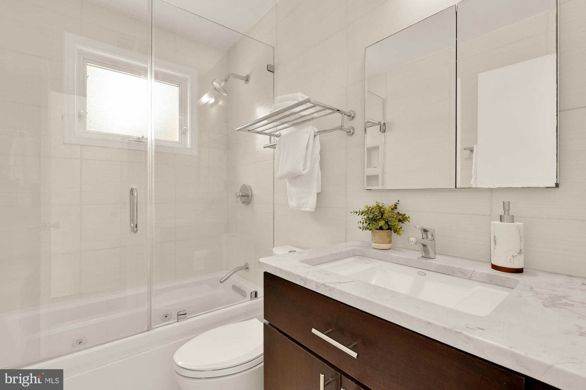 2400 41st Street Northwest, Unit 212 Washington, DC 20007 - Photo 20 of 24 a bathroom with a granite countertop sink a toilet and shower