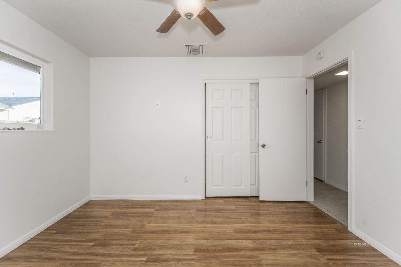412 East Church Avenue Ridgecrest, CA 93555 - Photo 21 of 39 a view of an empty room with wooden floor and a window