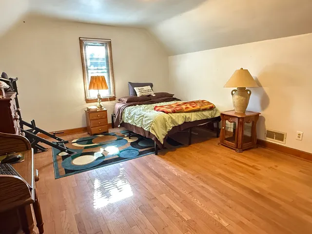 a bedroom with a bed and wooden floor