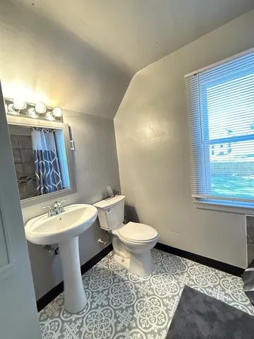 a white toilet sitting next to a bathroom sink