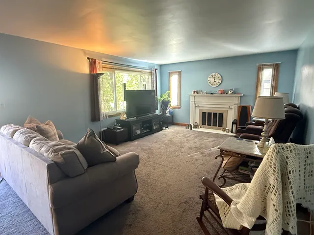 a living room with furniture a fireplace and a window